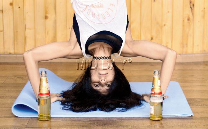 Intsructor Dhara Vachharajani demonstrates a headstand