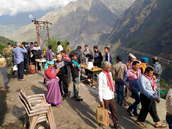 Army soldiers giving tea and snacks to devotees stranded at the Badrinath highway due to landslide on Saturday. Pic/PTI