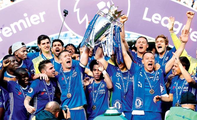 Chelsea skipper John Terry (right) and Gary Cahill (centre left) lift the Premier League trophy as teammates celebrate after the match against Sunderland at Stamford Bridge in London yesterday. Pic/AFP