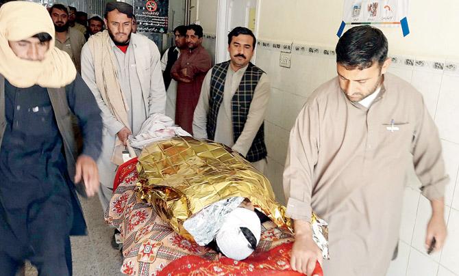 Pakistani relatives push a stretcher carrying a victim