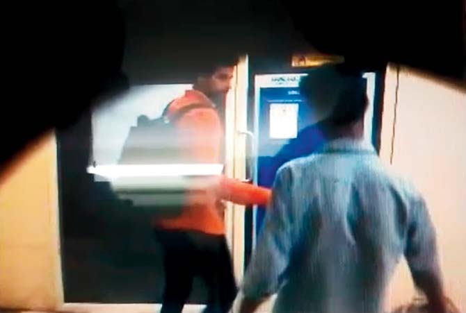 CCTV footage of Rakesh Pawar punching the code into the machine and leaving, while his accomplice looks on