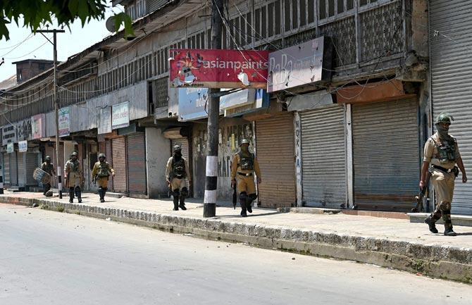 Security personnel petrolling a street during curfew in Downtown Srinagar. Pic/PTI