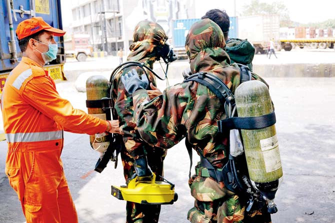 National Disaster Response Force (NDRF) personnel during the clean-up operation at the container depot, where the gas leak took place yesterday morning