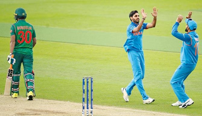 India’s Bhuvneshwar Kumar (centre) celebrates the wicket of Bangladesh’s Mahmudullah with skipper Virat Kohli during the International Cricket Council Champions Trophy warm-up match at the Kia Oval in London yesterday. Pic/Getty Images