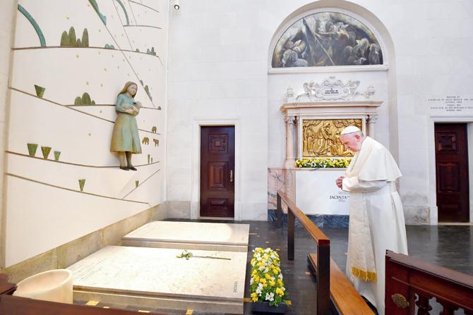 Pope Francis prays in front of the grave of two of the three little shepherds at the Shrine of Our Lady of Fatima in Portugal