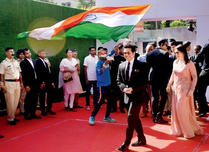 Sudhir Gautam waves the Indian tri-colour flag as India icon Sachin Tendulkar enters the grand premier of his biopic, Sachin: A Billion Dreams at PVR Icon in Versova on Wednesday. Pic/PTI
