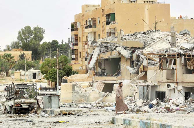A man walks past a bombed building in the town of Tabqa, about 55 km west of Raqa city. Pic/AFP