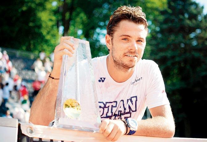 Swiss ace Stan Stan poses with the Geneva Open title  on Saturday. Pic/AFP