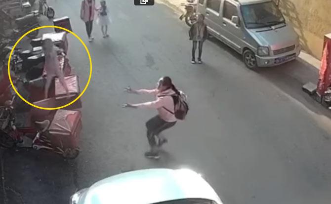 A screengrab from the video showing the girl rushing to catch the falling toddler (circled) in Zhengzhou, Henan, China. Pic/YouTube