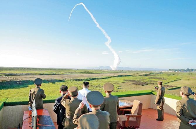 North Korean leader Kim Jong-Un (in white) watches the test of a new anti-aircraft guided weapon system at an undisclosed location. Pic/AFP