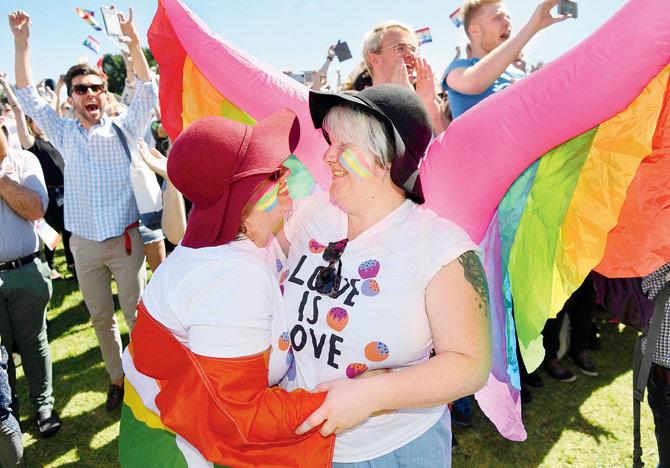 A couple embrace as supporters of the same-sex marriage “Yes” vote celebrate the announcement in a Sydney park. pic/afp