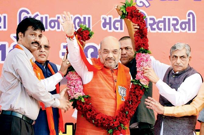 BJP National President Amit Shah waves at a public meeting in Vagra assembly in Bharuch