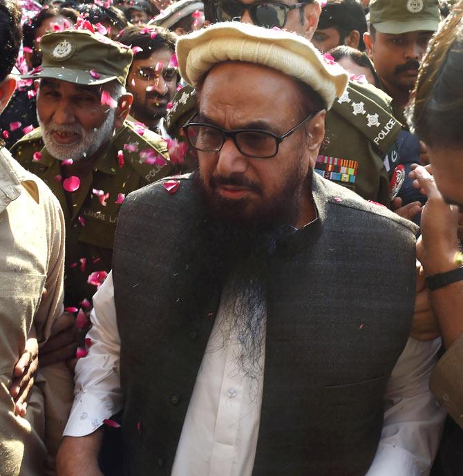 Pakistani police officials escort the head of the Jamaat-ud-Dawa (JuD) organisation Hafiz Saeed (C) as he arrives at a court in Lahore on November 22, 2017. A Pakistani court has ordered the release of one of the alleged masterminds of the 2008 Mumbai attacks, in which more than 160 people died, less than a year after he was placed under house arrest. Pic/AFP