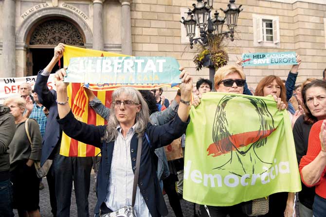 Demonstrators shout slogans while holding signs reading "Democracy" and "Freedom, we want you back at home" during a protest outside the Generalitat Palace in Barcelona on November 2, as members of the deposed Catalan government were being questioned in Madrid. Pic/AFP
