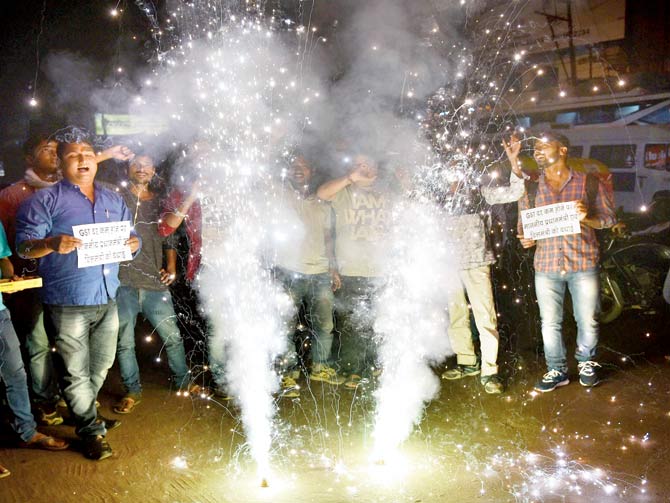Celebrations post revision of GST tax slab in Patna. Pics/PTI 