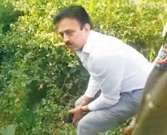 A grab from the video that shows Minister Girish Mahajan holding his pistol while waiting in the bushes for the leopard to emerge