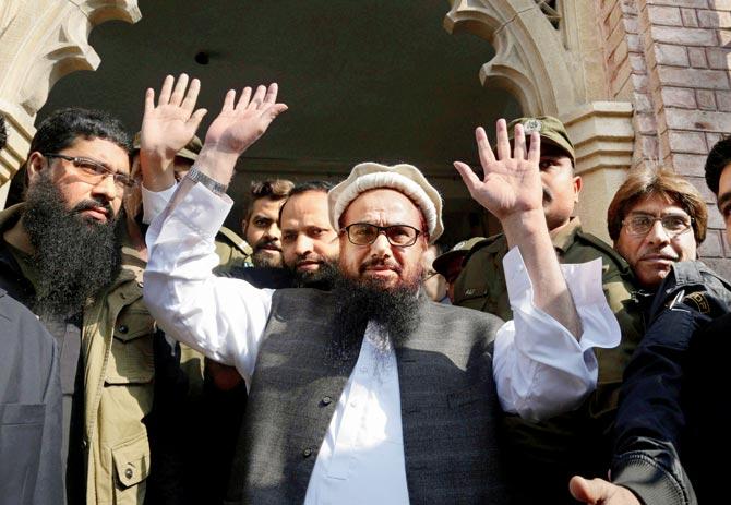 Hafiz Saeed, head of the Pakistani religious party, Jamaat-ud-Dawa, waves on his arrival to a court in Lahore, Pakistan, on Tuesday. Pic/AP/PTI