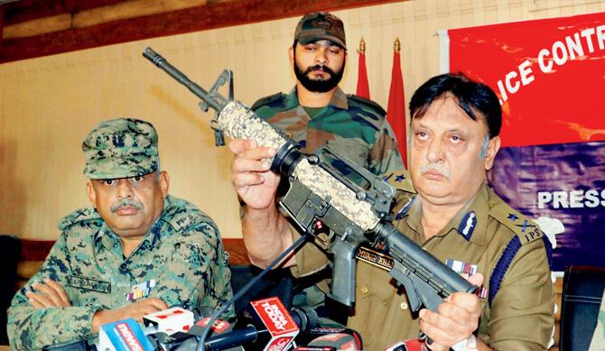 IG Police Kashmir Range Muneer Khan (right), displays a US-made M4 carbine rifle, recovered from the terrorists. Pic/PTI