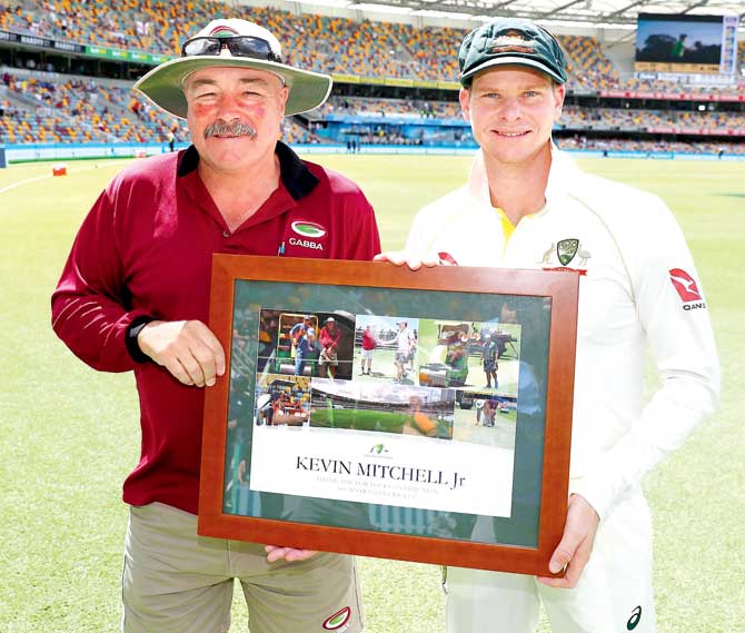Kevin Mitchell Jr poses with Australian captain Steve Smith during Day Two of the Brisbane Test on Friday. Mitchell Jr has been preparing the Gabba pitch for the last 27 years. Pic/Getty Images