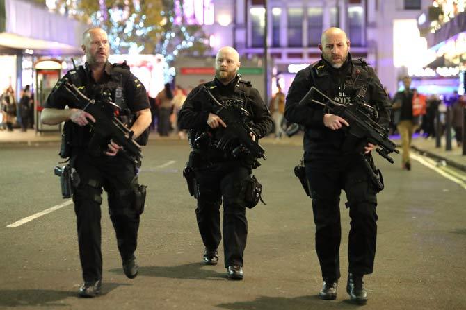 Armed police patrol near Oxford street as they respond to an incident in central London. Pic/AFP