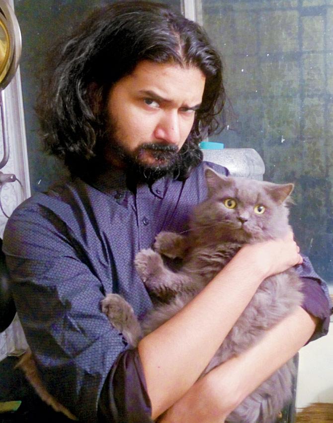 Manik Choudhary with his fluffy grey Persian, Billi