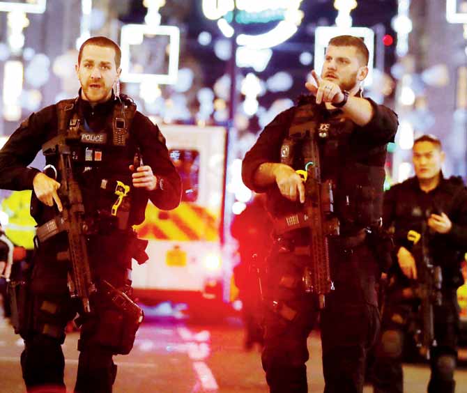 Armed policemen clear Oxford Street after gunshots were allegedly heard in London. pic/afp