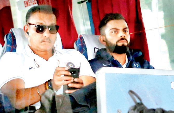 Virat Kohli and head coach Ravi Shastri in the team bus. Pic/PTI 