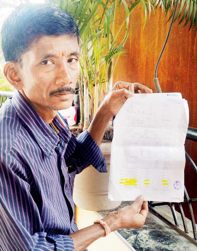 Victim Ravichandra Naik holds up the bank statement, which mentions details about the fraudulent transaction