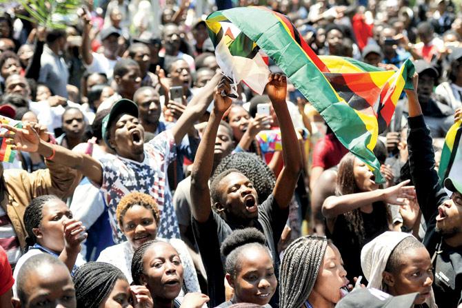 A man holding a flag of Zimbabwe takes part in a demonstration of University of Zimbabwes students, on November 20, to demand the withdrawal of Grace Mugabe’s doctorate. PIC/AFP