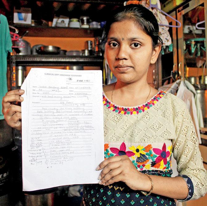 Varsha Sakpal holds up the discharge report she got after spending four days in hospital with a head injury from the disaster. Pic/Rajesh Gupta