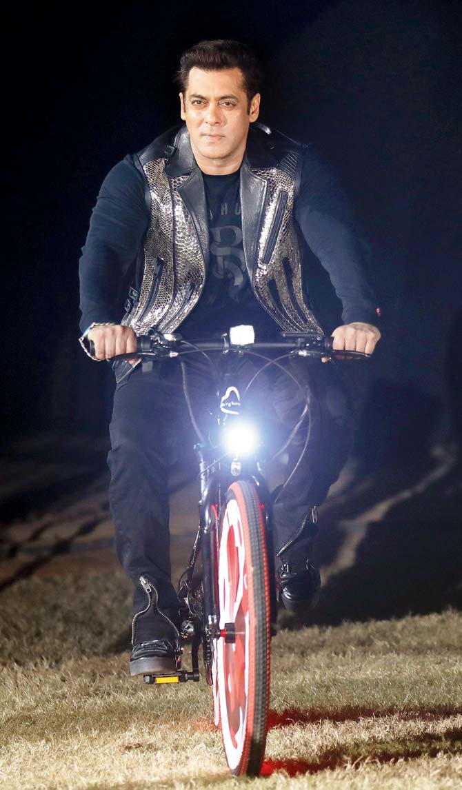 Actor Salman Khan makes his entry for the ISL-4 opening on a bicycle