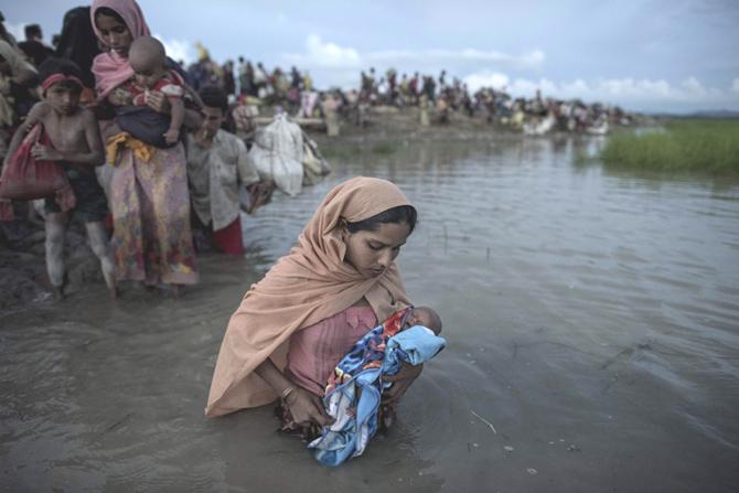 This file photo taken on October 09, 2017 shows Rohingya refugees wading while holding a child after crossing the Naf river from Myanmar into Bangladesh in Whaikhyang on October 9, 2017. US Secretary of State Rex Tillerson said November 22, 2017, that Myanmar
