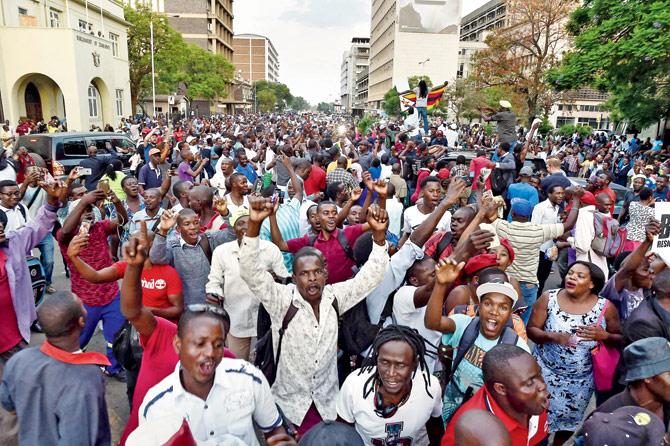 People celebrate in the streets of Harare after the resignation of Robert Mugabe. PIC/AFP
