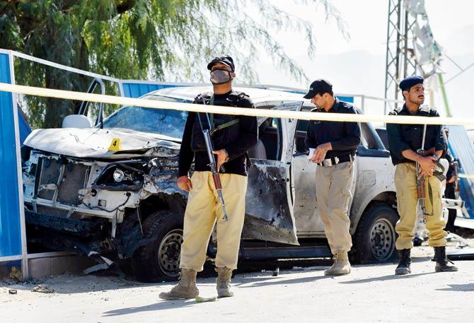 Pakistani security officials inspect a destroyed vehicle of a police officer at the site of a suspected suicide bomb attack in Quetta on Thursday. PIC/AFP