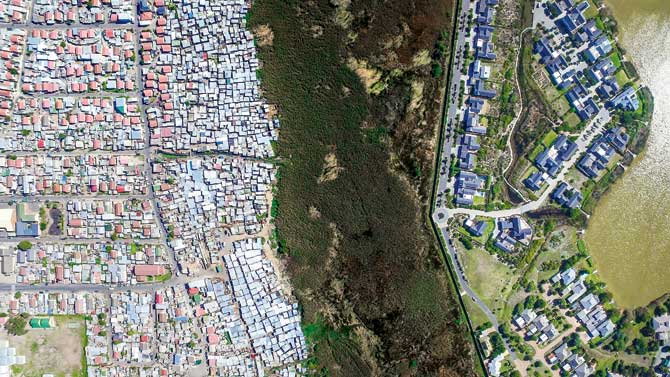 This was the first photo taken for Unequal Scenes. On the left is Masiphumele in Cape Town, where 38,000 people live in tin shacks; on the right is the wealthy Lake Michelle area. Separating them is a wetland patch.