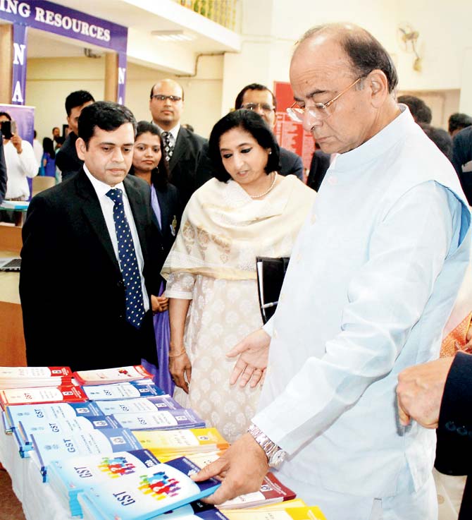 Union Minister for Finance and Corporate Affairs Arun Jaitley looks at a book titled ‘GST’ at a time when the economy is a cause for concern, at a function in Faridabad on Sunday. Pic/PTI