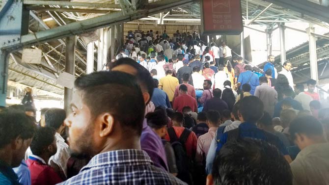 Commuters crowd on the staircase that leads up to the FOB connecting the station