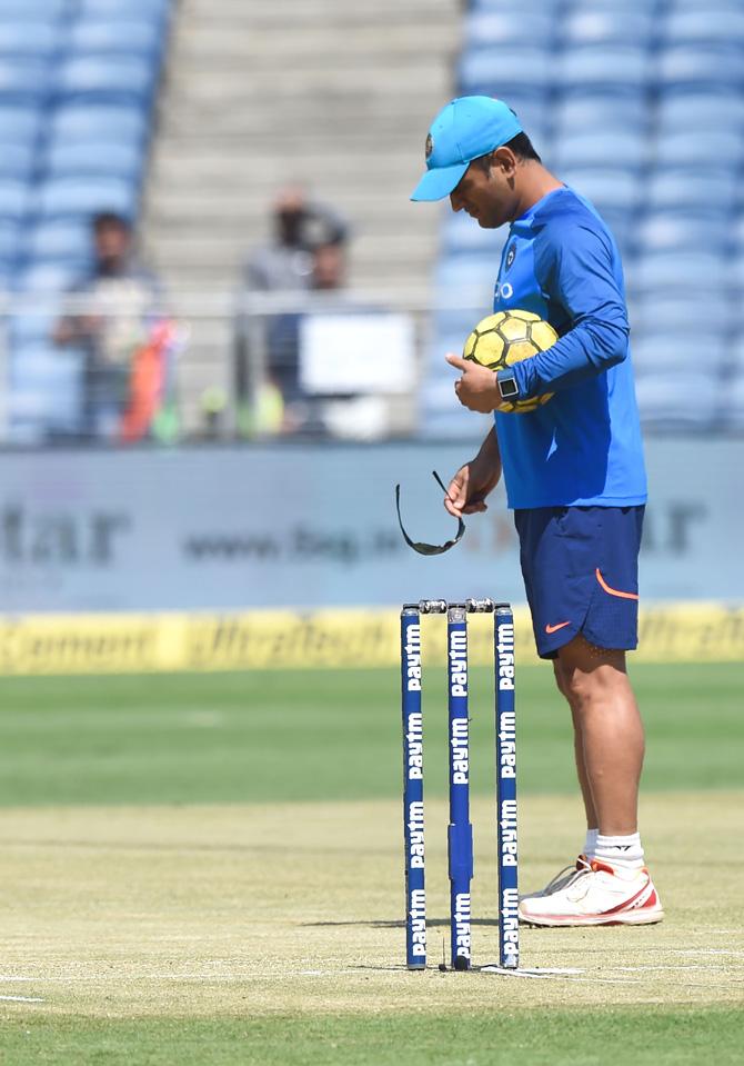 Indian cricketer Mahendra Singh Dhoni inspects the pitch ahead of the 2nd one day international (ODI) cricket match between India and New Zealand at The Maharashtra Cricket Association Stadium in Pune on October 25, 2017. India