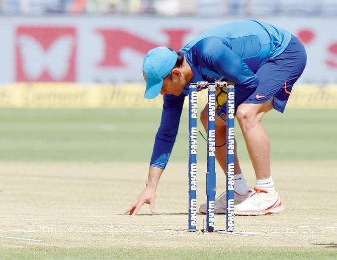 Former India skipper MS Dhoni inspects the pitch ahead of the 2nd ODI v NZ in Pune yesterday. Pic/AFP