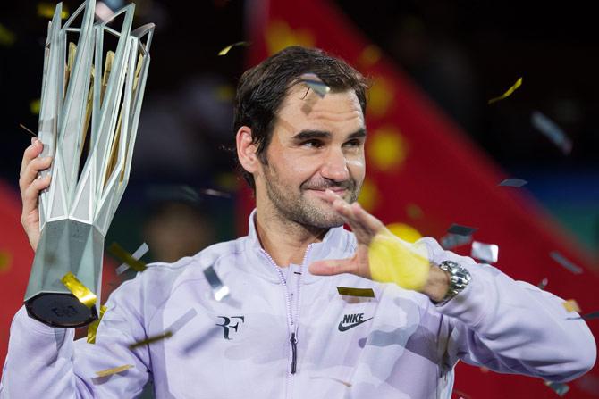 Roger Federer of Switzerland holds the trophy after winning his men