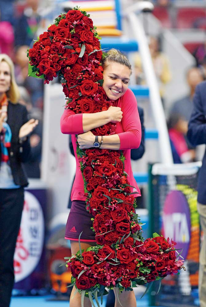 Simona Halep is presented with a bouquet in the shape of number 1 in Beijing on Saturday. Pics/AFP