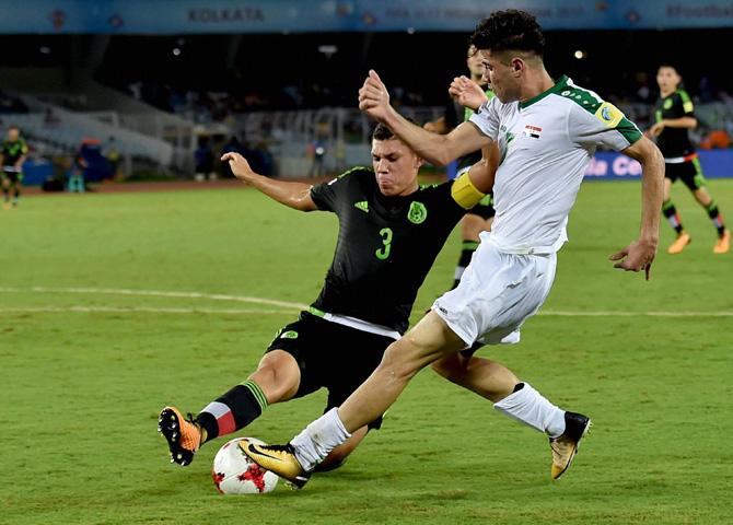 Iraq(white) and Mexico (Black-Neon Green) footballers vie for the ball during FIFA U-17 World cup match in Kolkata on Saturday. Pic/PTI