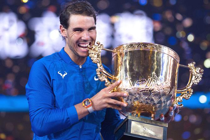 Rafael Nadal of Spain holds the trophy after winning the men