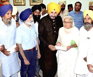 Navjot Singh Sidhu gives Rs 15 lakh to farmers whose crops were damaged