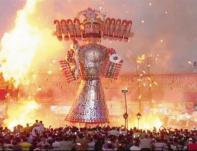 The Ravana effigy, which was uprooted, set ablaze. Pics/PTI and ANI