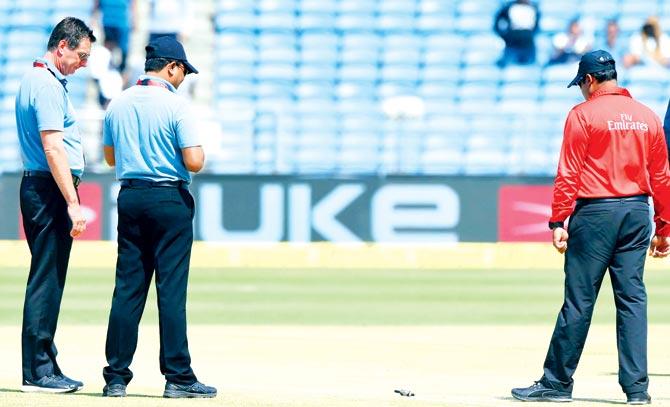 On field umpires Rod Tucker (left) and C Shamshuddin with reserve umpire Nitin Menon (right) inspect the Pune pitch on Wednesday. Pic/AFP