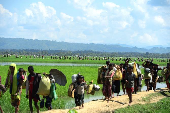 Rohingya refugees walk together after fleeing violence in Myanmar to reach Bangladesh in Palongkhali near Ukhia. Pic/AFP