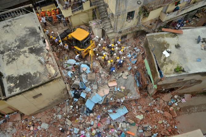 Fire personnel carrying out rescue work after a building collapsed due to a suspected cylinder blast at Ejipura area in Bengaluru on Monday. Pic/ PTI