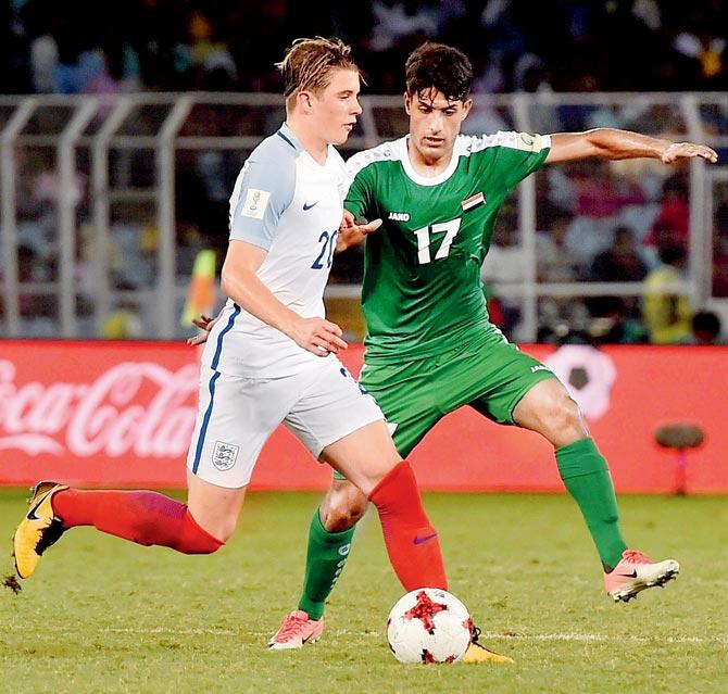 An England (left) and Iraq player vie for the ball during the FIFA U-17 World Cup match in Kolkata on Saturday. Pic/PTI