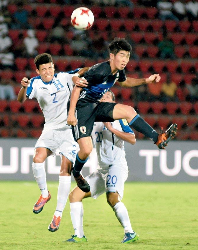 A Japanese player (in blue jersey) heads the ball ahead of two Honduras defenders in Guwahati yesterday. Pic/PTI